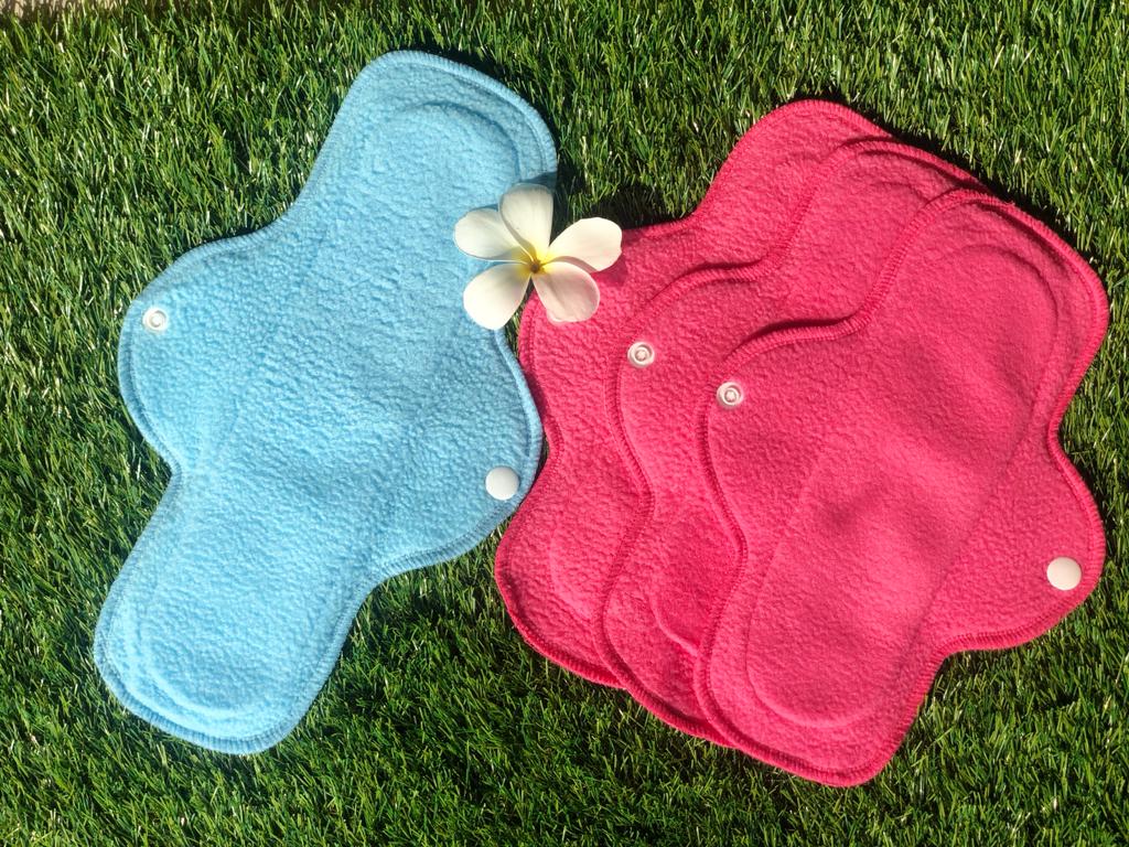 Care-O-Safe reusable pads drying on grass